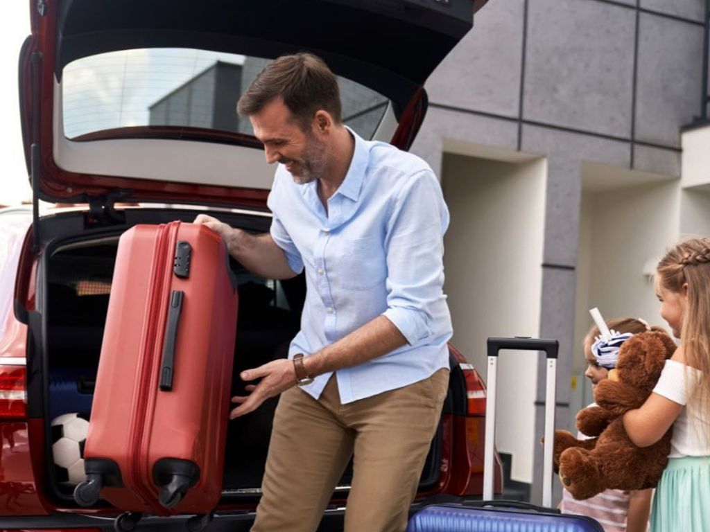 Familia recibiendo su auto de Rent a Car aeropuerto al comenzar sus vacaciones.